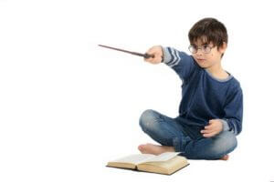 child reading harry potter and holding wand pic