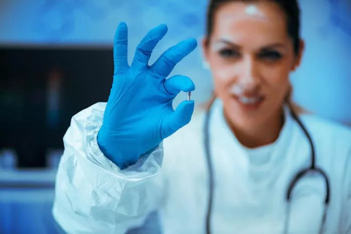 doctor holding up small chip implant