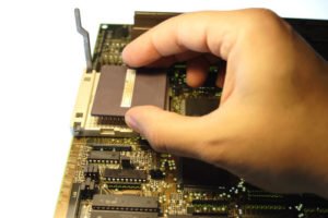 person working on computer's circuit board